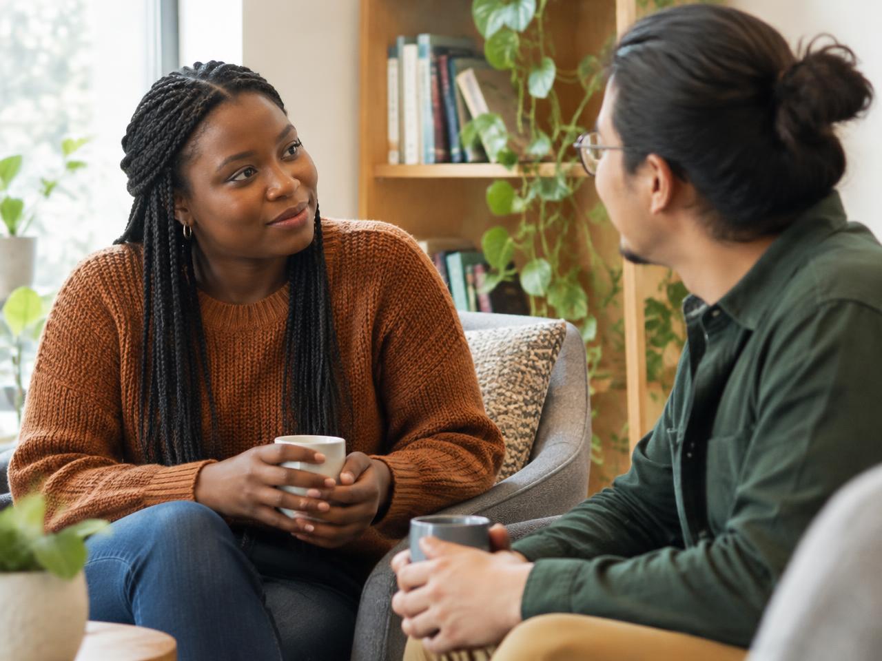 Illustrative colleagues having a calm, open conversation over coffee